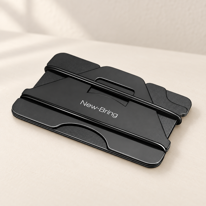Black aluminium card holder with two elastic bands on an ivory desk.