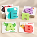 Wooden alphabet puzzle cards with colourful letters on an ivory tabletop