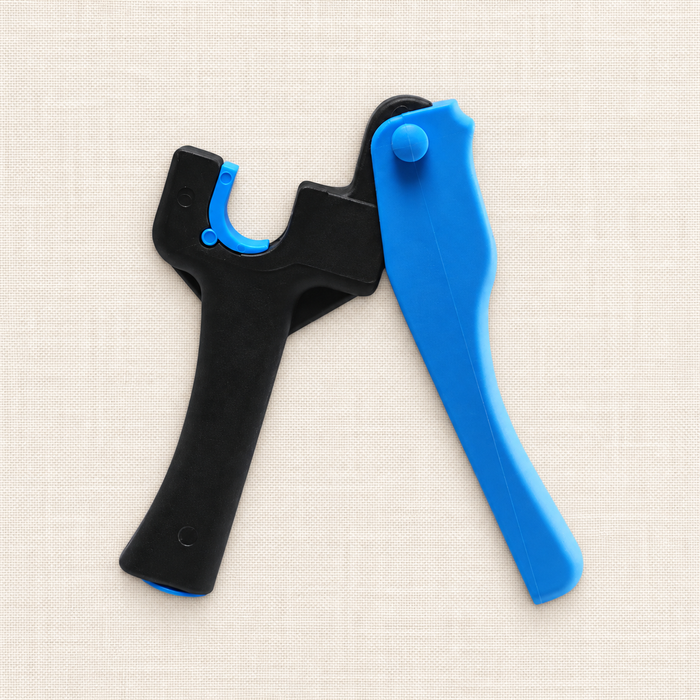 Black and blue irrigation hole punch lying on ivory linen