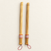 Pair of wooden massage tapping sticks on an ivory surface.