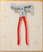Silver multifunction hammer pliers with red handles on a work mat.