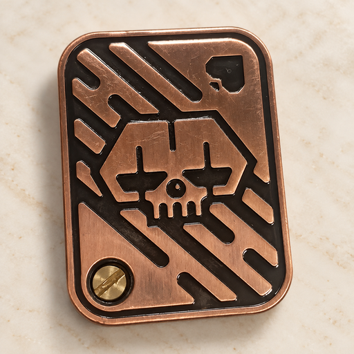 Bronze metal rectangular object with skull relief on an ivory surface