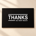 Black thank you card with white lettering on ivory tabletop
