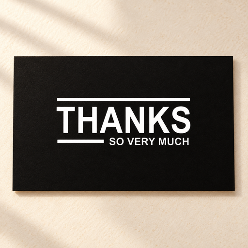 Black thank you card with white lettering on ivory tabletop