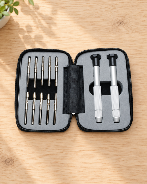 Open grey precision screwdriver case containing two silver handles and ten metal attachments on a wooden desk.