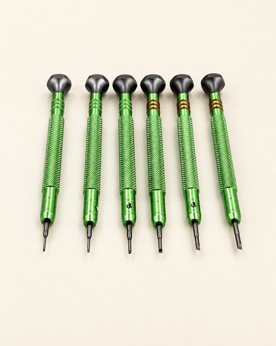 Six green precision screwdrivers arranged on an ivory work surface.