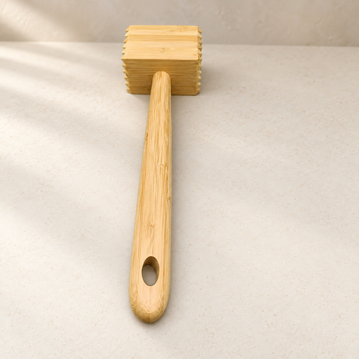 Bamboo meat tenderizer resting on ivory stone
