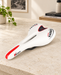 White VADER bicycle saddle with red accents on an ivory stone workbench.