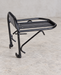 Black front bicycle rack standing on a light concrete workshop floor.