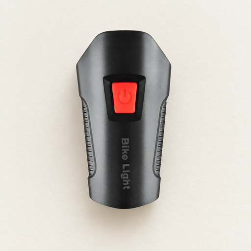 Black bicycle light with red power button on ivory surface