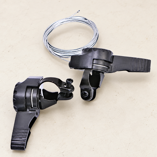 Rear view of two bicycle thumb shifters and silver cable