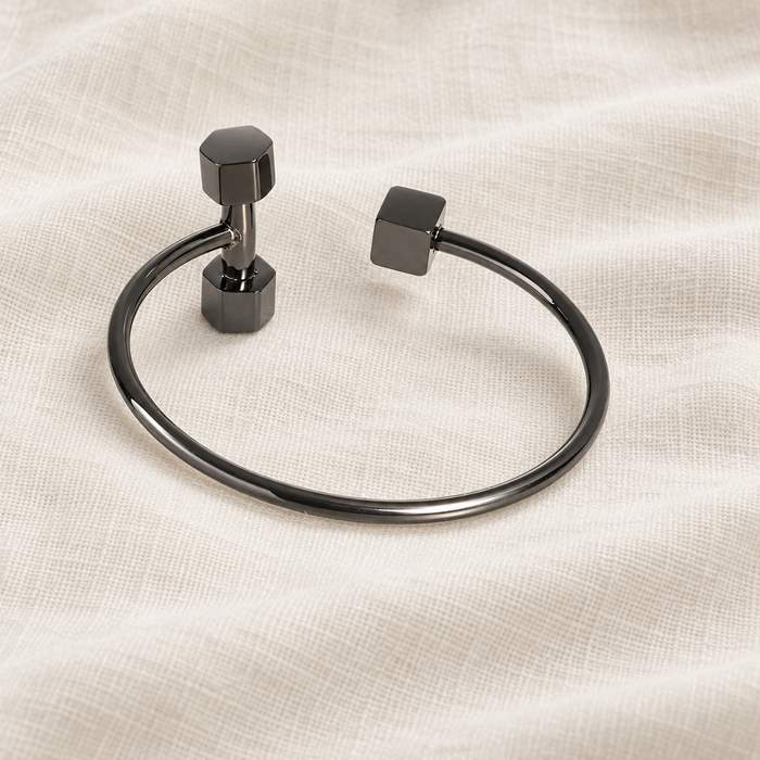 Dark metallic open dumbbell bangle on ivory linen
