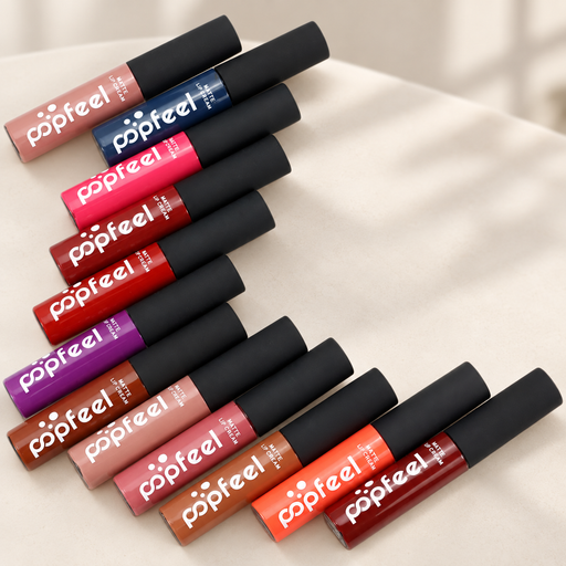 Twelve colourful matte lip cream tubes with black caps on an ivory surface.