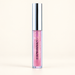 Pink iridescent lip gloss in a clear tube with a silver cap on an ivory surface.