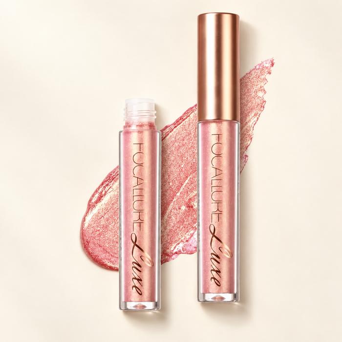 Pink shimmer lip glaze tubes with rose-gold cap on ivory surface