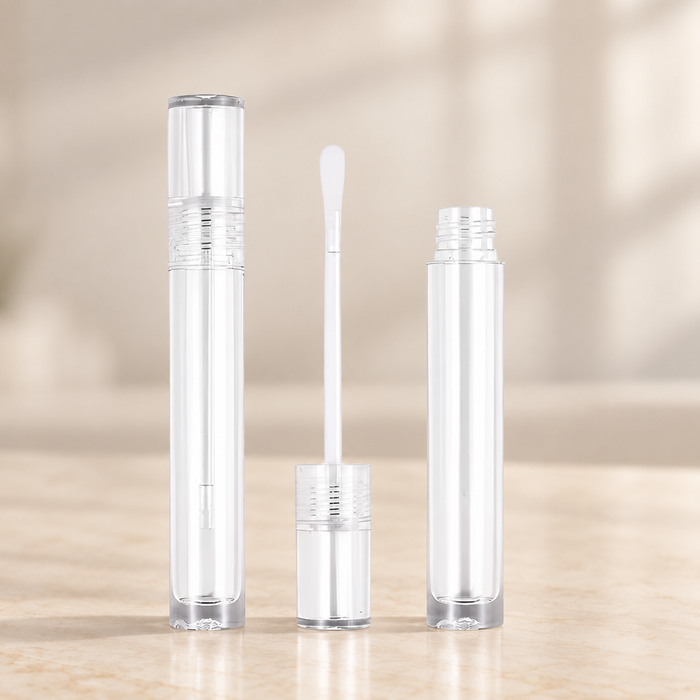 Transparent empty cosmetic tubes and white applicator on ivory vanity.