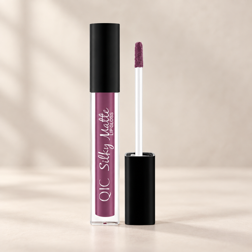 Plum lip gloss tube and applicator on an ivory vanity.