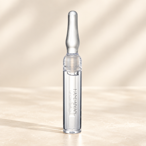 Clear lip oil tube with a silver cap on an ivory surface