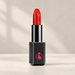 Red lipstick in a black case with a pink heart-and-hand emblem on an ivory vanity.