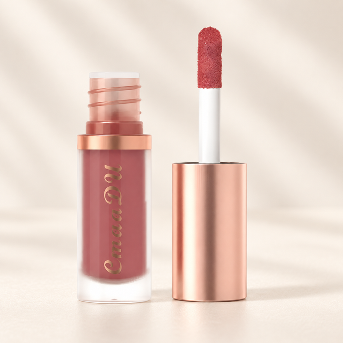 Mauve lip gloss with a rose gold cap and applicator on ivory