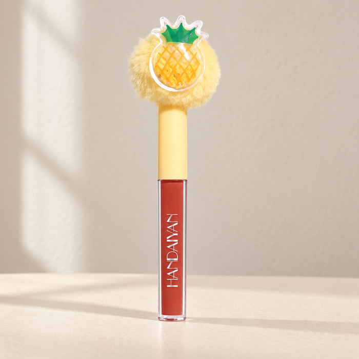 Lip gloss with yellow pompom and pineapple decoration