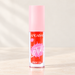 Pink-capped red-orange lip tint tube on ivory vanity.