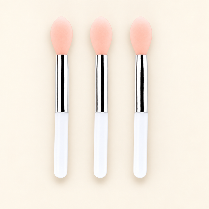 Three mini lip brushes with peach tips and white handles