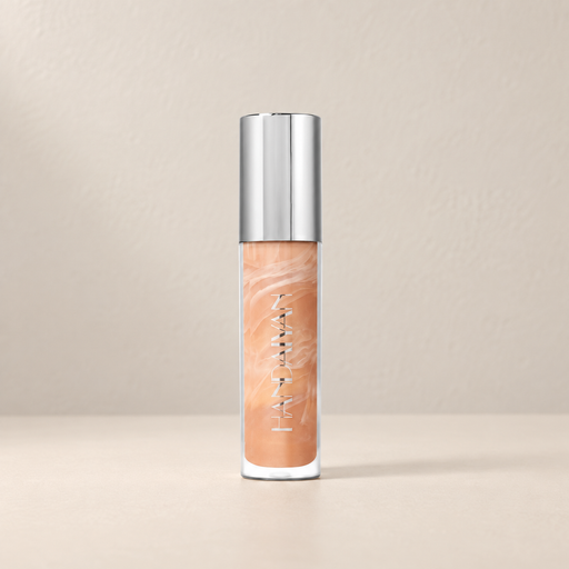 Peach marbled lip gloss with silver cap on an ivory surface