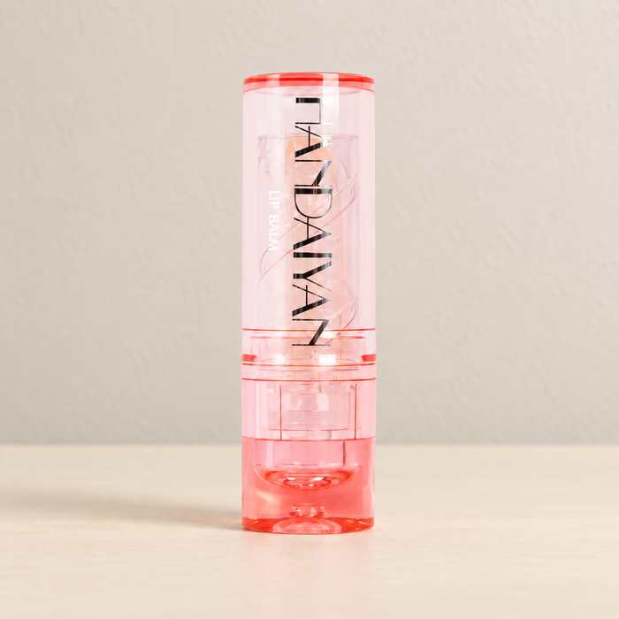 Transparent pink capped lip balm on an ivory surface