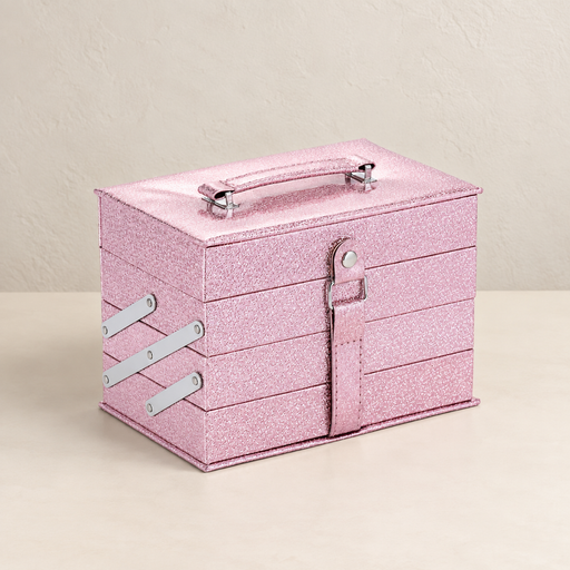 Closed pink glitter makeup case with silver fittings on an ivory table