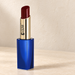 Burgundy lipstick in a gold barrel with blue case on ivory