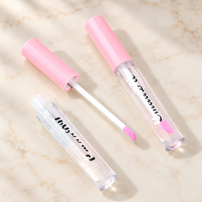 Clear lip gloss tubes with pink caps and white applicator.