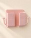 Empty blush pink wall organizer with two side hooks on an ivory wall.