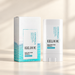 White skin care stick with turquoise and white box on ivory