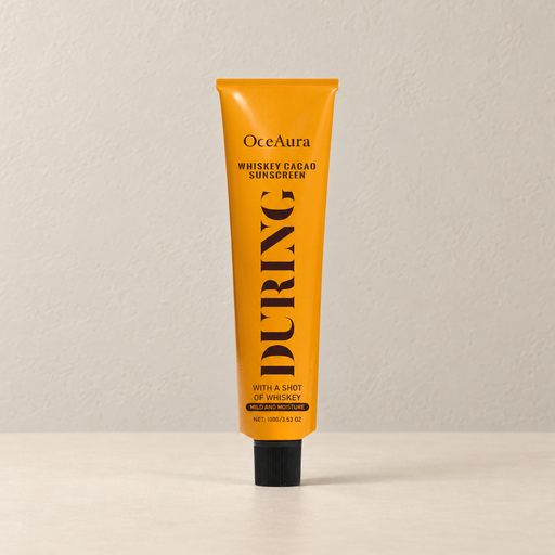 Orange OceAura tube with black cap on an ivory surface