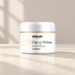 White cream jar with green lettering and gold details on an ivory surface.