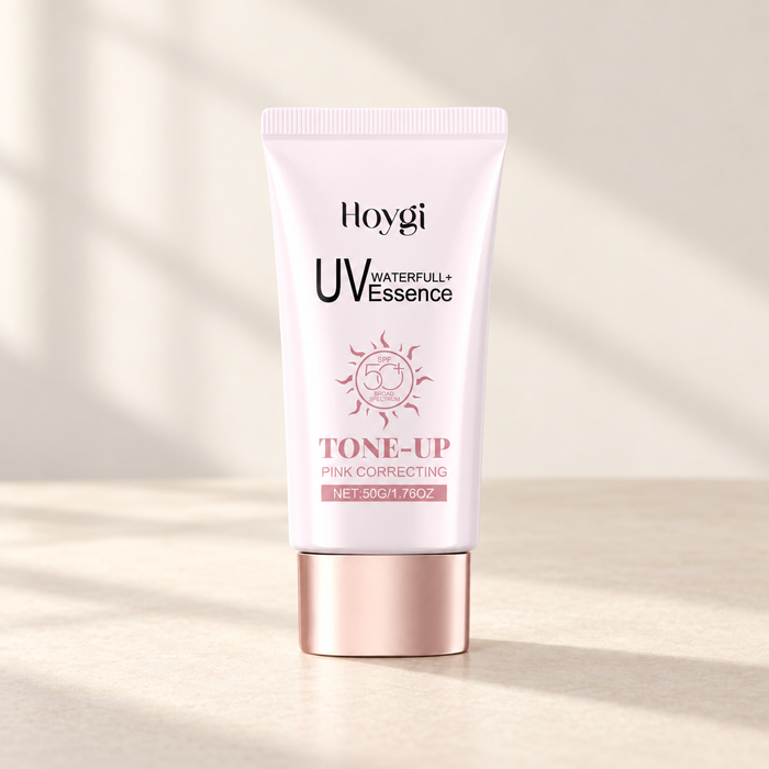 Pale pink sunscreen tube with a rose-gold cap on an ivory surface.