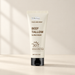 Ivory sunscreen tube with a black cap on an ivory surface.