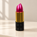 Metallic magenta lipstick-shaped USB drive on ivory vanity