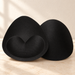 Pair of black triangular foam inserts on ivory surface