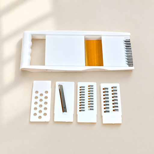 White vegetable slicer with four interchangeable inserts on an ivory surface.