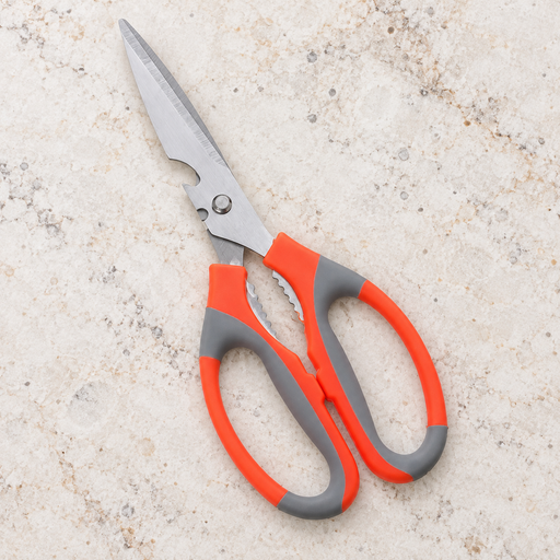 Orange and grey kitchen scissors on a pale stone countertop.