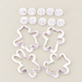 Four white animal baking cutters with ten expression stamps on an ivory surface.