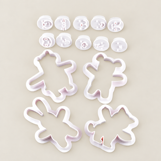 Four white animal baking cutters with ten expression stamps on an ivory surface.