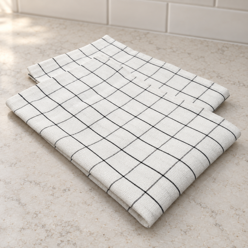 White kitchen tea towel with a fine dark checked pattern, folded on a pale countertop.