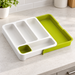 White and green cutlery organiser on a kitchen worktop.