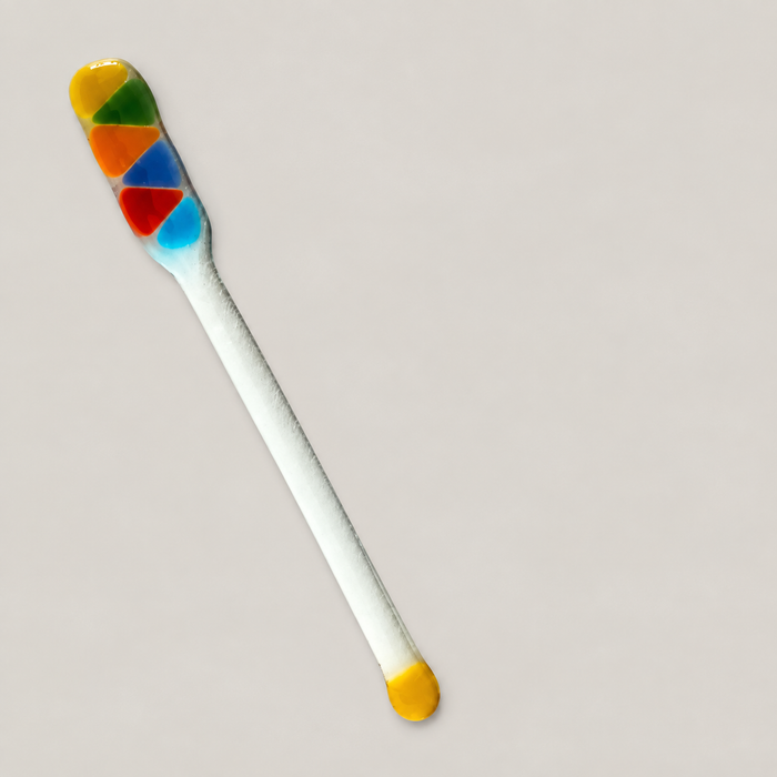 Multicolour glass stirring rod on ivory surface