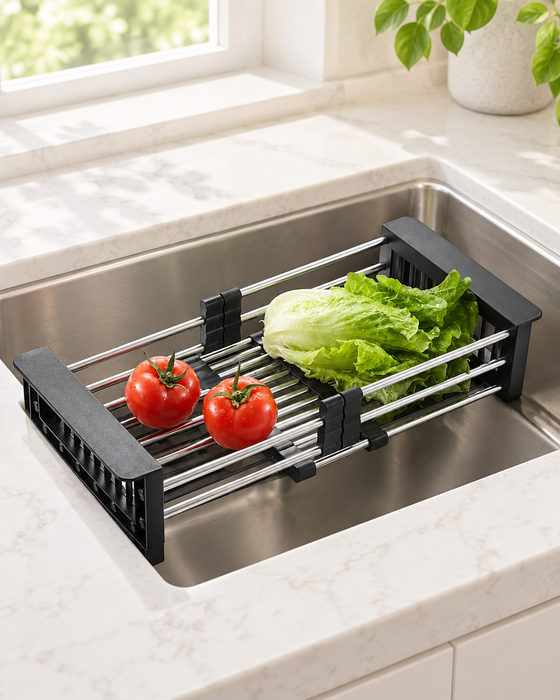 Black and silver extending drain basket holding two tomatoes and lettuce over a kitchen sink.