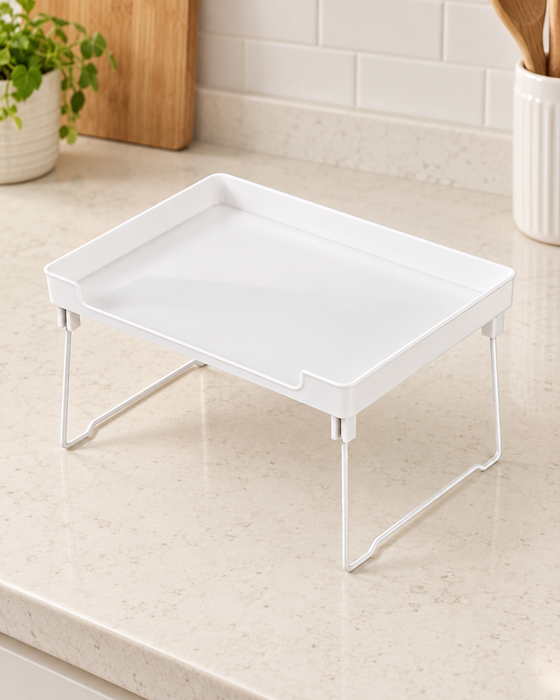 White organizer shelf with folding wire legs on an ivory kitchen countertop.