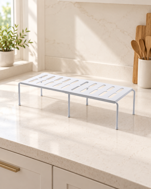 White extendable organizer shelf with six legs on a kitchen counter.
